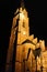 Gothic cathedral church structure with clock tower in night illumination in Guben, Germany