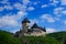 Gothic royal castle Karlstejn in green forest during summer with blue sky and white clouds, Central Bohemia, Czech republic, Europ
