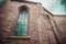 Gothic style ornate window and gray brick wall of the church. Medieval architecture in Europe. Tallinn old town details.