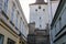 Gothic tower of the Velvary Gate, town fortifications built in the pre-Hussite period in sunny day, street of historic medieval