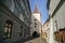 Gothic tower of the Velvary Gate, town fortifications built in the pre-Hussite period in sunny day, street of historic medieval