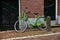 Gouda, South Holland/The Netherlands - February 15 2020: bright green locked bike in front of a brick wall and doors of a building