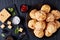 Gougeres, cheese puffs balls on a black plate