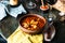 Goulash or stew in copper pan with spoon on rustic kitchen table. Eintopf, chili con carne. Traditional hungarian dish. Homemade