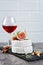 Gourmet appetizer of white brie cheese or camembert with fresh figs, nuts and glass of red wine for tasting