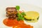 Gourmet beef tongue with green, beautiful  potato gratin and sause on a plate on white background