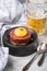 Gourmet beefsteak Tatar with lean raw beef filet, capers, egg yolk, onions, toast bread on black plate with spoons, beer, kitchen