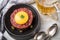 Gourmet beefsteak Tatar with lean raw beef filet, capers, egg yolk, onions, toast bread on black plate with spoons, beer, kitchen