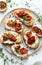 Gourmet Bruschetta With Roasted Tomatoes and Fresh Basil on a White Plate