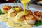 Gourmet chef cooking grilled scallops in butter lemon sauce with cajun spices and herbs