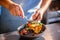 Gourmet chef in uniform preparing meal, stirs with spoon vegetable in frying pan