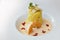 Gourmet dish from saffron risotto with vegetable and herb topping, a large prawn and crustacean sauce in a modern white plate,