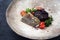 Gourmet fried European skrei cod fish filet with kalette and black venus rice on a rustic design plate
