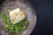 Gourmet fried European skrei cod fish filet with purslane lettuce and herbs on a modern design plate