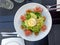 Gourmet green salad plate served with prosciutto and ricotta white cheese