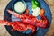 Gourmet Red Lobster Halves Plated on Elegant Black Dish in Fine Dining Restaurant Setting