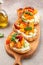 Gourmet sandwiches bread toast, bruschetta with cream cheese, peaches, tomatoes and green basil leaves