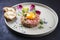 Gourmet tartar raw from beef fillet with yellow of the egg grilled and baguette on modern design dish