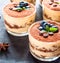 gourmet tiramisu dessert in a glass sprinkled with cocoa and decorated with coffee beans on a dark background, luxury dessert