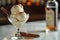 Gourmet Vanilla Ice Cream Scoops in Elegant Glass Bowl with Cinnamon Sticks and Bottle of Bourbon in Soft Focused Background