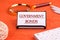 Government Bonds text on a white business card on a stand on an orange background, next to a magnifying glass, a calculator and