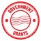 GOVERNMENT GRANTS text on red round postal stamp sign