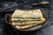 Gozleme Turkish flatbread with greens and cheese. Black background. Top view