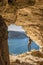 Gozo island Malta, young man in a cave looking out over the ocean and a View of Ramla Bay, from inside Tal Mixta Cave