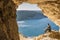 Gozo island Malta, young man in a cave looking out over the ocean and a View of Ramla Bay, from inside Tal Mixta Cave