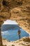 Gozo island Malta, young man in a cave looking out over the ocean and a View of Ramla Bay, from inside Tal Mixta Cave