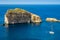 Gozo, Malta - Amazing Fungus Rock at Dwejra bay with sailboat