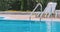 Grab bars ladder in the blue swimming pool