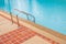 Grab bars ladder in the blue swimming pool