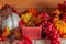 A `Grace` sign  sits next to metal pumpkin and grapes  on a decorated Thanksgiving mantel.