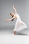 Graceful, attractive ballerina in white dress dancing