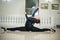 Graceful ballerina doing the splits on the marble floor. Gorgeous ballet dancer performing a split on glossy floor