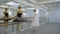 Graceful ballerinas dance near barre in ballet studio.