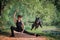 Graceful ballet boy in a black leather jacket sitting jumping with  big black dog