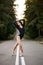 Graceful ballet dancer or classic ballerina dancing on road in forest.