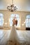 A graceful bride in a lace dress pulls her hands up.Room in loft style.