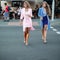 Graceful business women in elegant dresses walking in city .