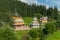 Graceful church with a chapel with beautiful domes in the background of a high forest