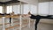 Graceful classical ballet dancer in sport clothes practicing standing split stretching position at ballet barre in dance