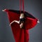 Graceful dancer on aerial silks posing upside down