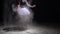 Graceful dancer in tutu and dust in the dark
