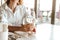 Graceful hand of a caucasian woman in a white shirt is hoding a wineglass in a restaurant. Night out, wine tasting, close-up