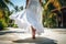 A graceful lady in long white skirt walk in luxury resort. Summer tropical vacation concept.