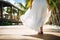 A graceful lady in long white skirt walk in luxury resort. Summer tropical vacation concept.