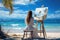 A graceful lady work on a painting at beach. Summer tropical vacation concept.