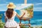 A graceful lady work on a painting at beach. Summer tropical vacation concept.